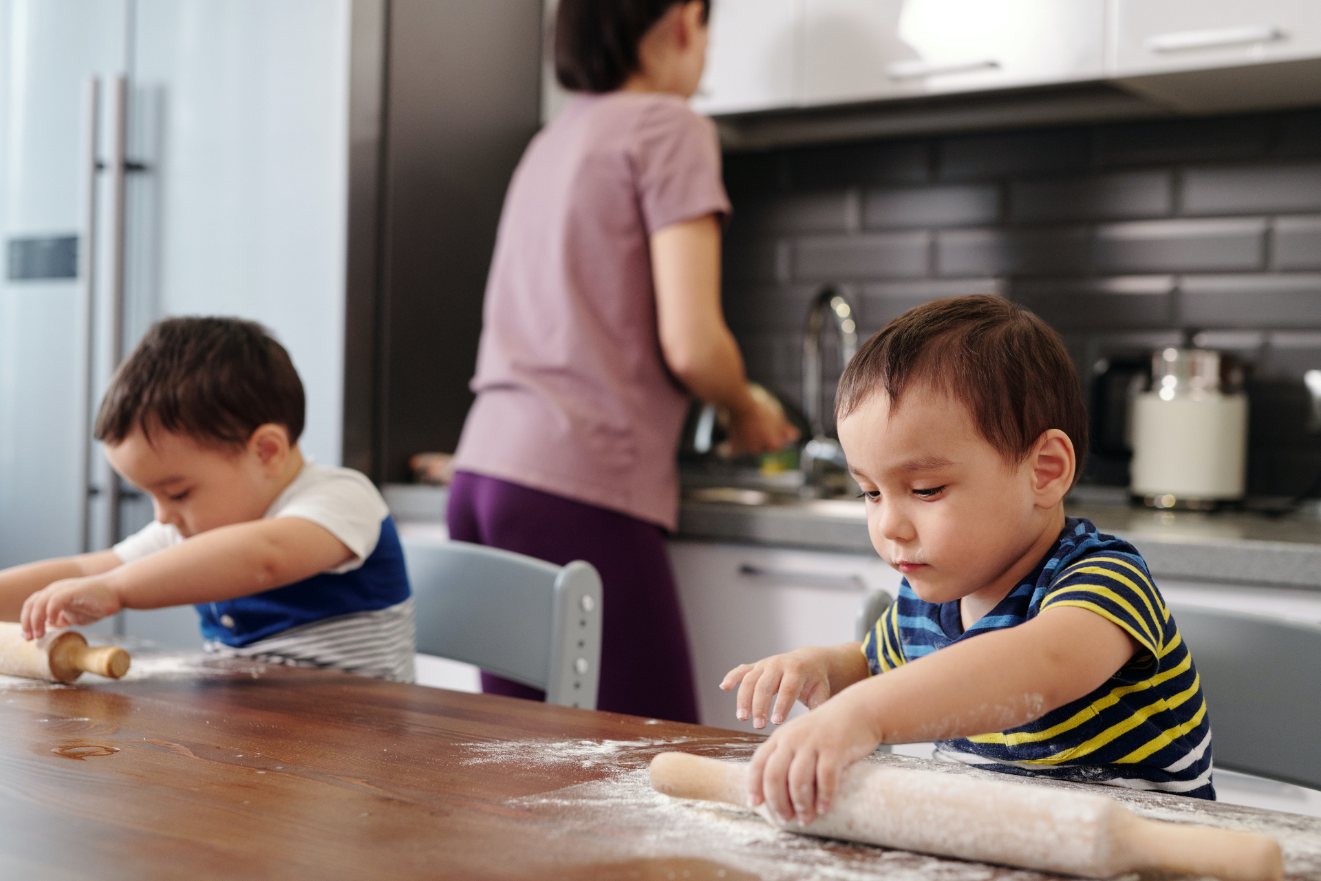 two little boys helping mom in kitchen